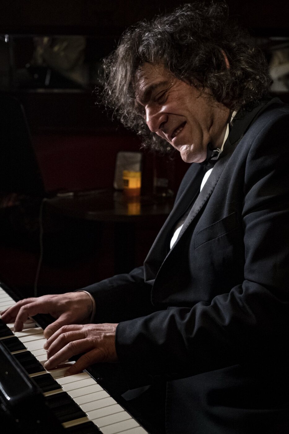 Robin Finesilver playing piano and singing in a candlelit Prague lounge
