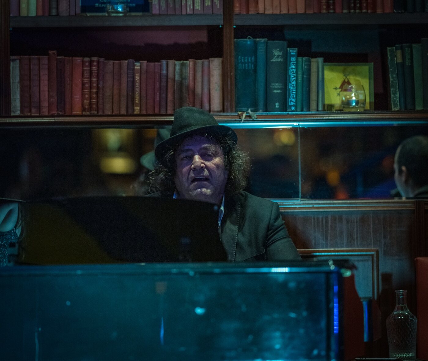 Robin Finesilver at the piano under blue light at Bar and Books