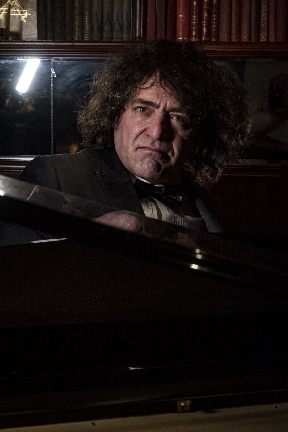 Robin Finesilver resting at the grand piano between numbers