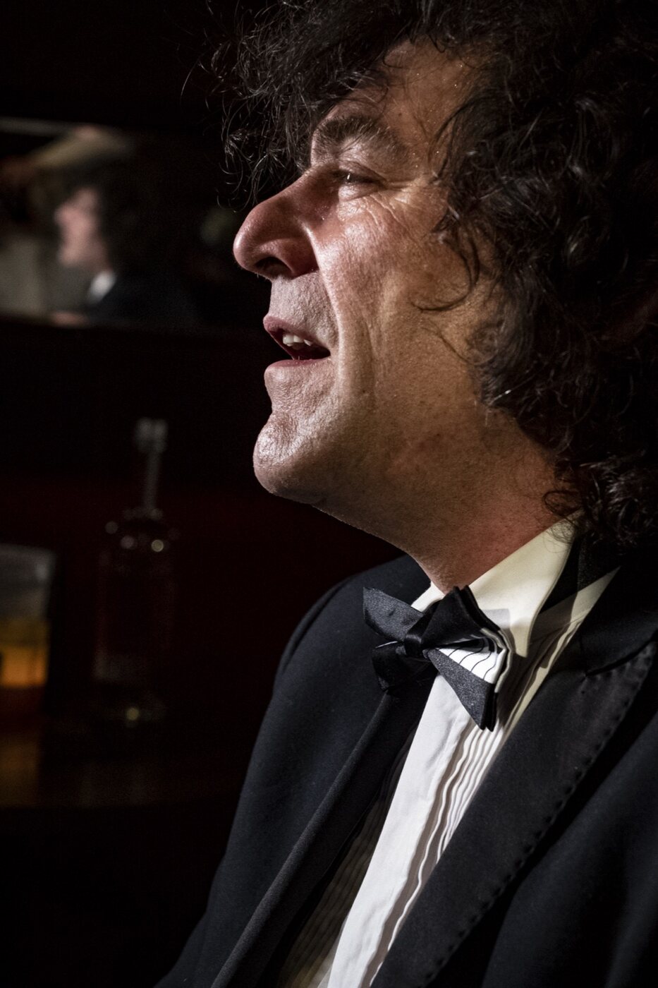 Lamplit profile of Robin Finesilver performing
